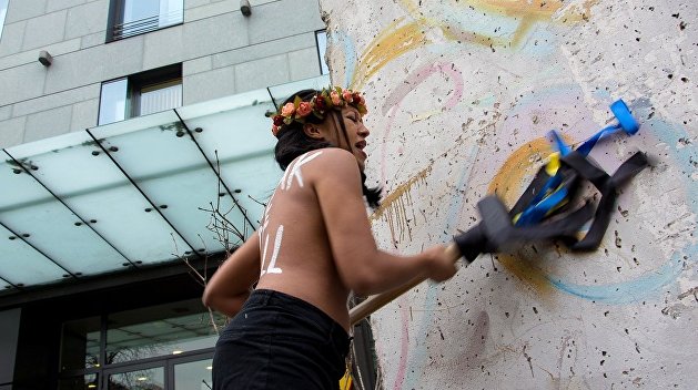 О стену головой за безвиз: Femen разбили фрагмент Берлинской стены у немецкого посольства в Киеве