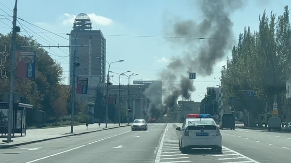 Автомобиль в центре Донецка горит после попадания украинского снаряда 