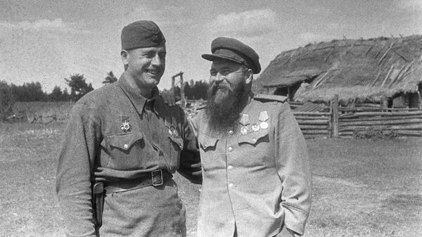  Командир соединения 1-й Украинской партизанской дивизии имени дважды Героя Советского Союза Сидора Ковпака генерал-майор Петр Петрович Вершигора (справа) и командир полка Давид Ильич Бакрадзе (слева) принимают поздравления с присвоением им 7 августа 1944 года звания Героев Советского Союза