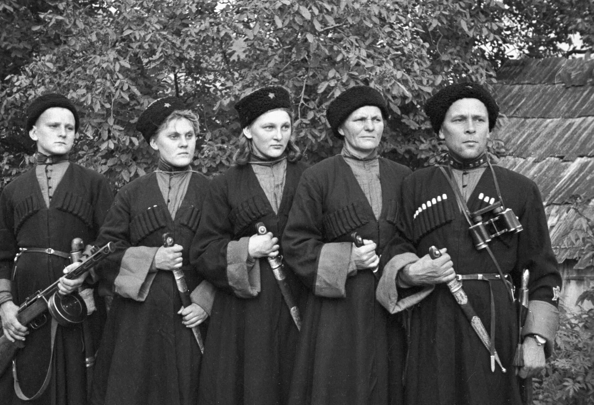 Семья Гордея Кириченко, добровольно вступившая в казачий полк. Справа налево: гвардии политрук пулеметного эскадрона Гордей Зубенко, его жена Евдокия - повар эскадрона, дочь Наталия - пулеметчица, дочь Нинель - санинструктор эскадрона и сын Александр - пулеметчик Семья Гордея Кириченко, добровольно вступившая в казачий полк. Справа налево: гвардии политрук пулеметного эскадрона Гордей Зубенко, его жена Евдокия - повар эскадрона, дочь Наталия - пулеметчица, дочь Нинель - санинструктор эскадрона и сын Александр - пулеметчик - РИА Новости, 1920, 23.05.2025