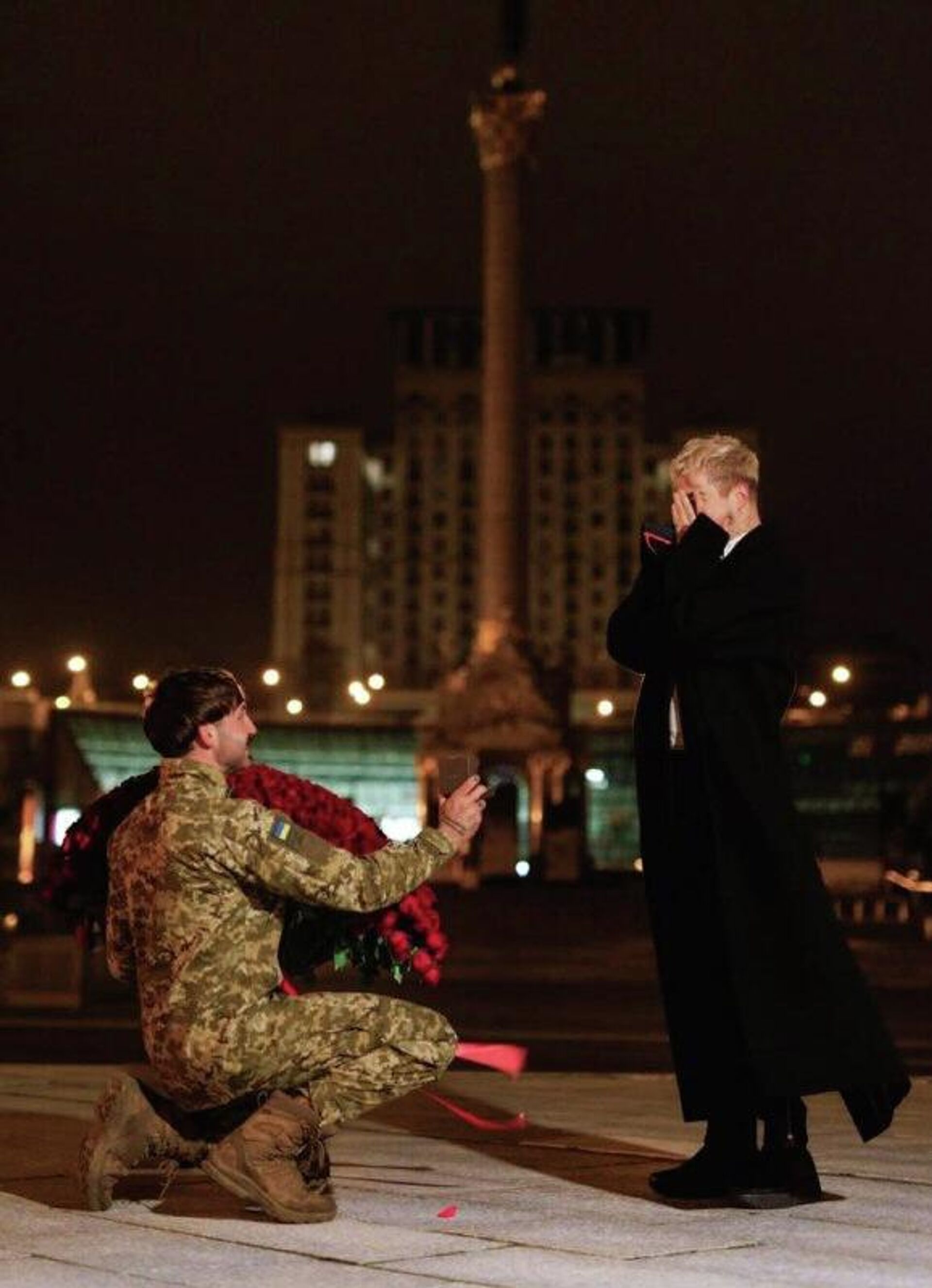 #украина_под_микроскопом: Ничего необычного – в Киеве на Майдане на фоне гостиницы «Украина» и Монумента Независимости ВСУшник делает предложение украинскому певцу Melovin - РИА Новости, 1920, 20.02.2026