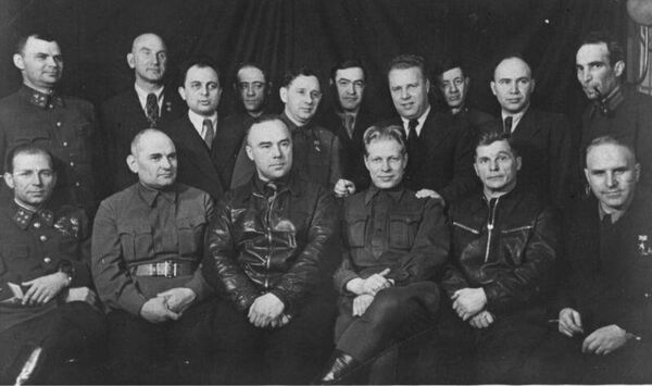 Работники советской оборонной промышленности в редакции газеты Правда. Сидят, слева направо: конструктор артиллерии Илья Иванов, нарком боеприпасов Бориса Ванников, авиаконструктор Николай Поликарпов, нарком вооружения Дмитрий Устинов, авиаконструктор Сергей Ильюшин, конструктор авиационного вооружения Борис Шпитальный. Во 2-м ряду: конструктор артиллерии Василий Грабин, конструктор авиадвигателей Александр Микулин, журналист Правды Семён Гершберг, директор Танкограда Исаак Зальцман, директор Московского авиазавода №30 Павел Воронин, нарком авиапрома Алексей Шахурин, 1-й замнаркома авиапрома Пётр Дементьев, заместитель начальника военного отдела Правды Лазарь Бронтман. Москва, октябрь 1942 года