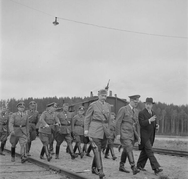 Карл Маннергейм, Адольф Гитлер, президент Финландии Ристо Рюти. На заднем плане, с жезлом в руке — генерал-фельдмаршал Вильгельм Кейтель. Аэродром Иммола, 4 июня 1942 года