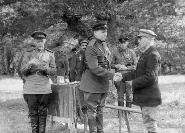 Начальник штаба украинского партизанского движения Тимофей Строкач награждает партизана.
На фото на втором плане справа от Строкача — заместитель начальника Украинского штаба партизанского движения по диверсиям Илья Старинов, слева — комиссар 1-й Украинской партизанской дивизии Семён Руднев. 1943 год Начальник штаба украинского партизанского движения Тимофей Строкач награждает партизана.
На фото на втором плане справа от Строкача — заместитель начальника Украинского штаба партизанского движения по диверсиям Илья Старинов, слева — комиссар 1-й Украинской партизанской дивизии Семён Руднев. 1943 год