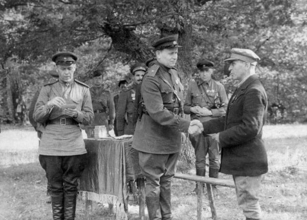 Начальник штаба украинского партизанского движения Тимофей Строкач награждает партизана. 
На фото на втором плане справа от Строкача — заместитель начальника Украинского штаба партизанского движения по диверсиям Илья Старинов, слева — комиссар 1-й Украинской партизанской дивизии Семён Руднев. 1943 год