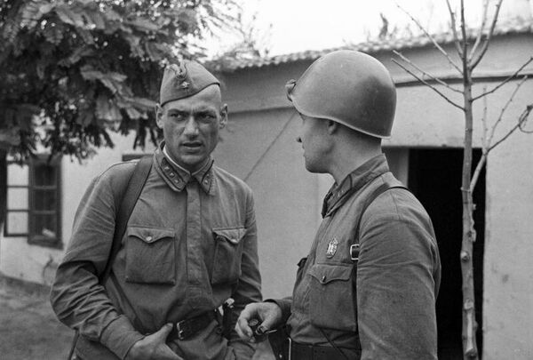 Фронтовой корреспондент газеты Известия Константин Симонов (справа) разговаривает с политруком 25-й стрелковой Чапаевской дивизии в Одессе. 1 августа 1941 года