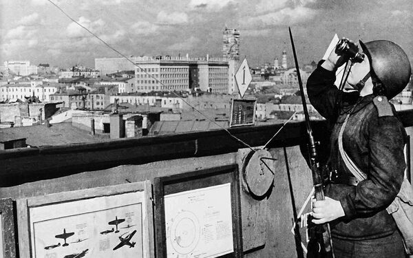 Девушка-военнослужащая войск МПВО на боевом дежурстве. Москва, 1943 год (На заднем плане видны здание наркомата обороны на Знаменке и колокольня Иван Великий в Кремле)