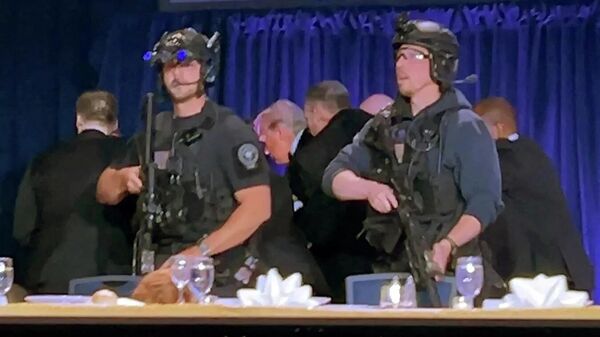 Сотрудники службы безопасности выводят президента США Дональда Трампа из зала после того, как мужчина открыл огонь во время ежегодного ужина Ассоциации корреспондентов Белого дома в Вашингтоне