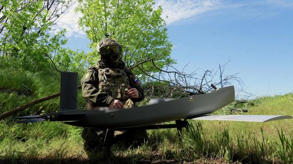 Техник готовит ударный БПЛА самолетного типа к вылету Техник готовит ударный БПЛА самолетного типа к вылету
