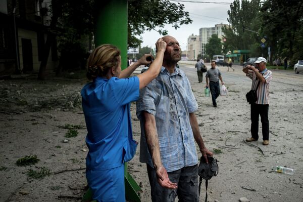 Врач оказывает помощь пострадавшему от артиллерийского обстрела в Луганске.