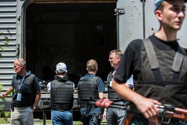 Сотрудники миссии ОБСЕ на станции города Торез перед отправкой в Донецк поезда с пятью рефрижераторными вагонами с телами погибших Сотрудники миссии ОБСЕ на станции города Торез перед отправкой в Донецк поезда с пятью рефрижераторными вагонами с телами погибших