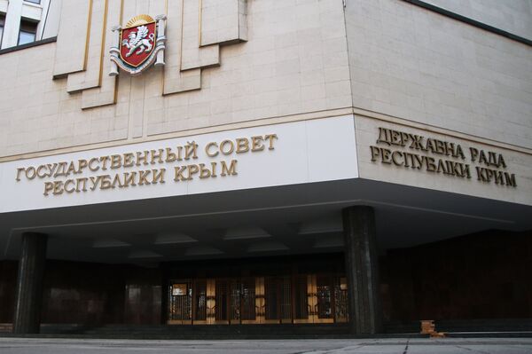 Рабочие крепят на фасад Государственного совета Республики Крым название парламента на украинском языке