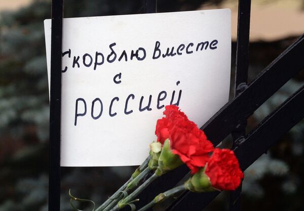 Люди несут цветы к Генконсульству РФ в Эстонии в память о жертвах крушения ТУ-154 в Сочи