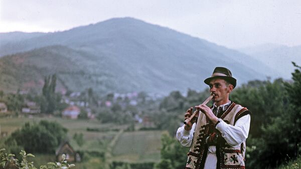 Житель Верховины играет на свирели Житель Верховины играет на свирели