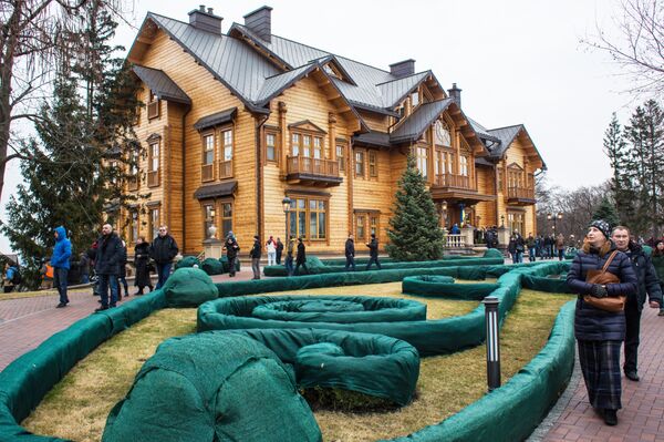 Люди гуляют по территории оставленной резиденции президента Украины Виктора Януковича Межигорье под Киевом