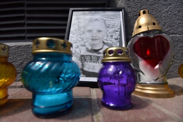 Портрет погибшего мальчика и свечи у здания департамента полиции во Львове