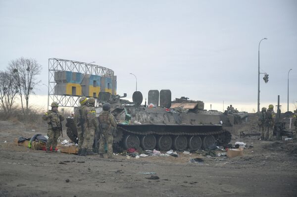 Украинские военные дежурят у подбитой бронетехники на окраине Харькова.