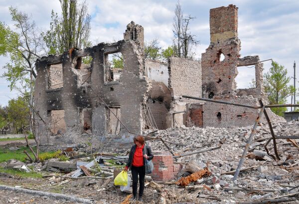 Женщина на обломках уничтоженной жилой малоэтажной застройки в городе Рубежное