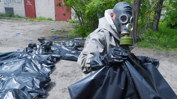 Участник похоронной команды вывозит тела для захоронения в городе Рубежное